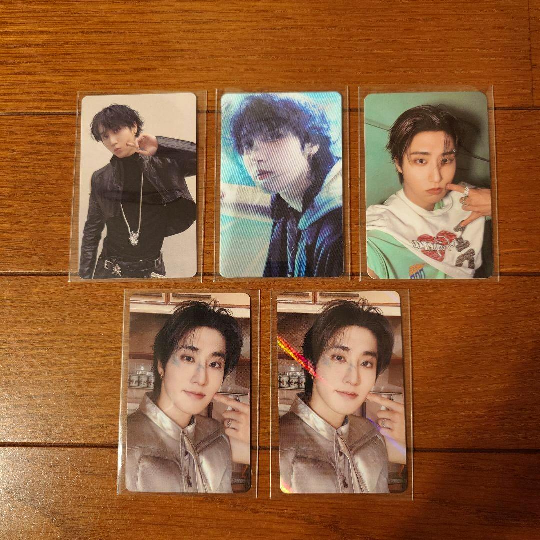 Five Stray Kids THIS&THAT photocard fronts featuring member images arranged on a wooden surface.