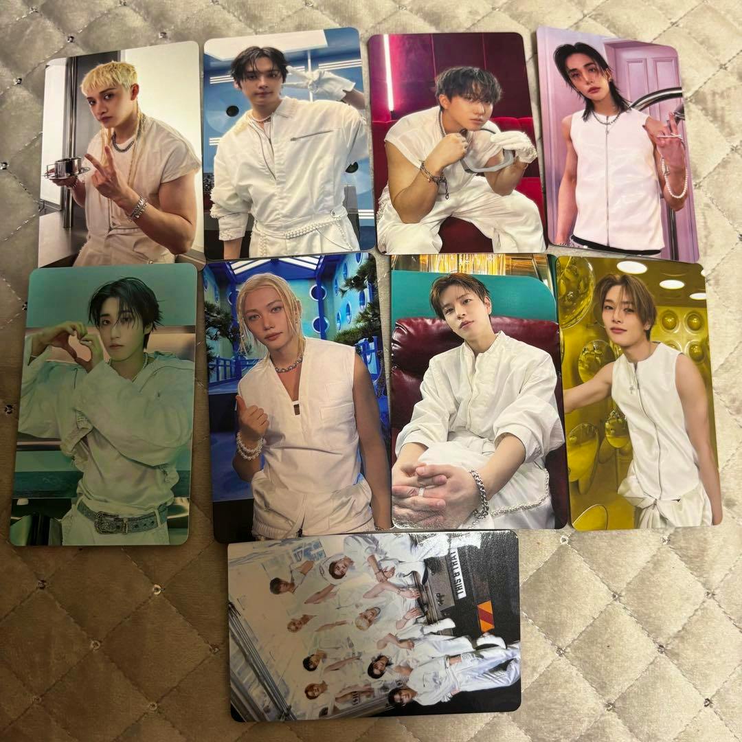 A collection of Stray Kids THIS＆THAT HMV photocards laid out on a quilted surface, including individual portrait cards and a group card.