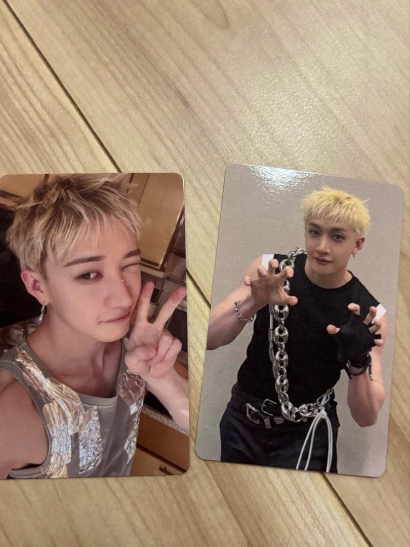 Two Stray Kids THIS & THAT photocard fronts showing Bangchan in two different poses laid on a wood surface.