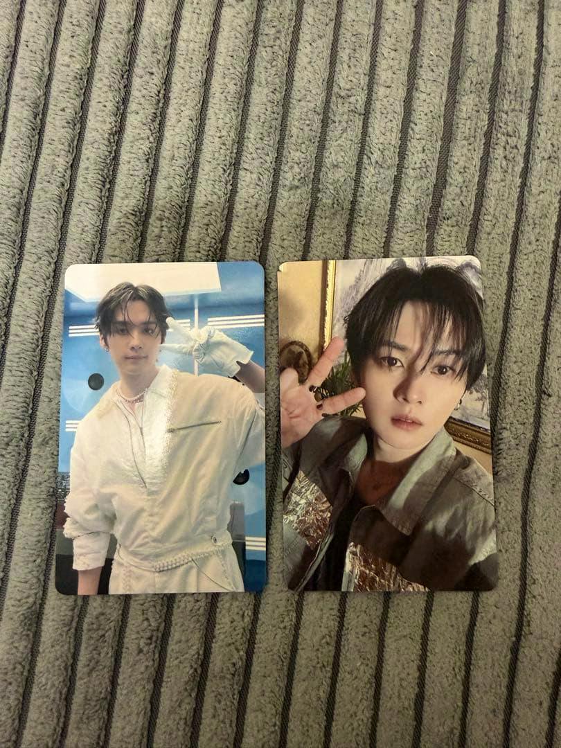 Two photocards from the Stray Kids this&that HMV set placed side by side on a gray striped fabric.
