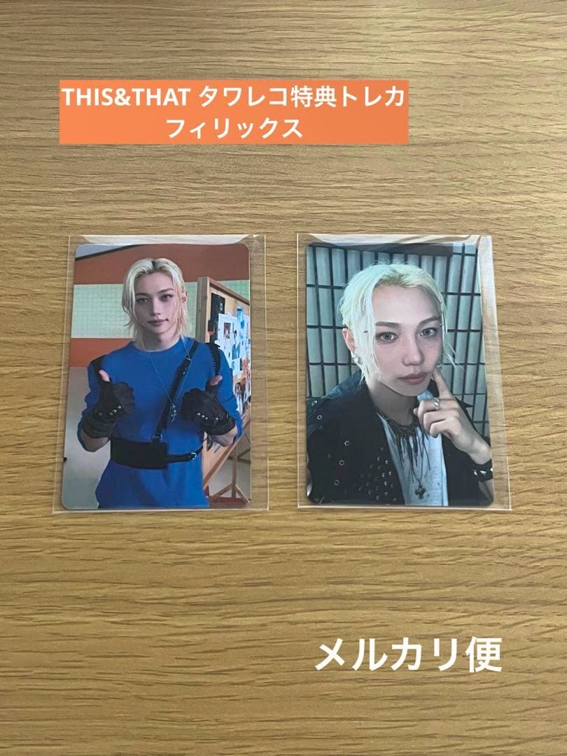 Two sleeved Stray Kids THIS&THAT photocards showing Felix front photos placed side-by-side on a wood surface with Japanese text at the top.