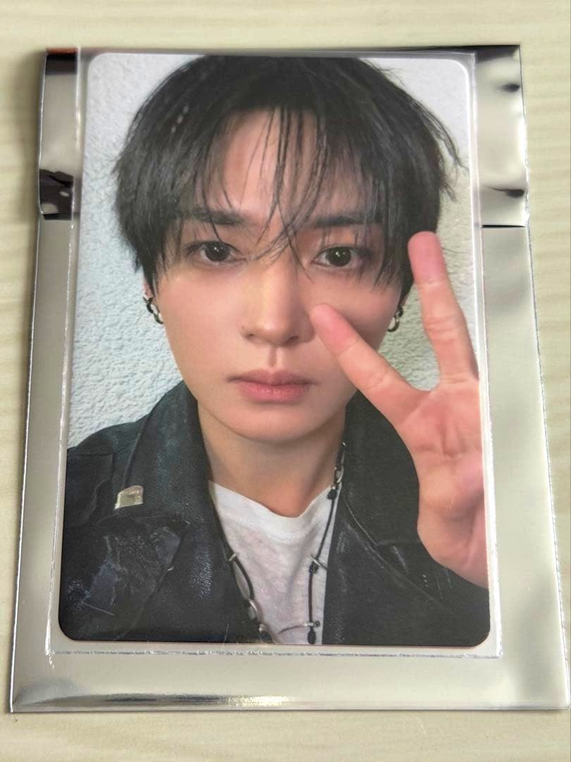 Front of the photocard showing a close-up portrait of the artist making a peace sign.