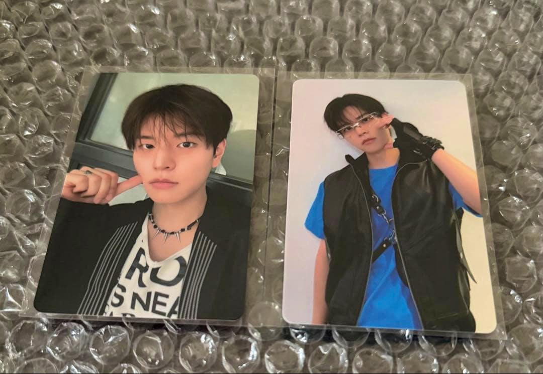 Two Stray Kids "THIS&THAT" photocards featuring Seungmin placed on bubble wrap.