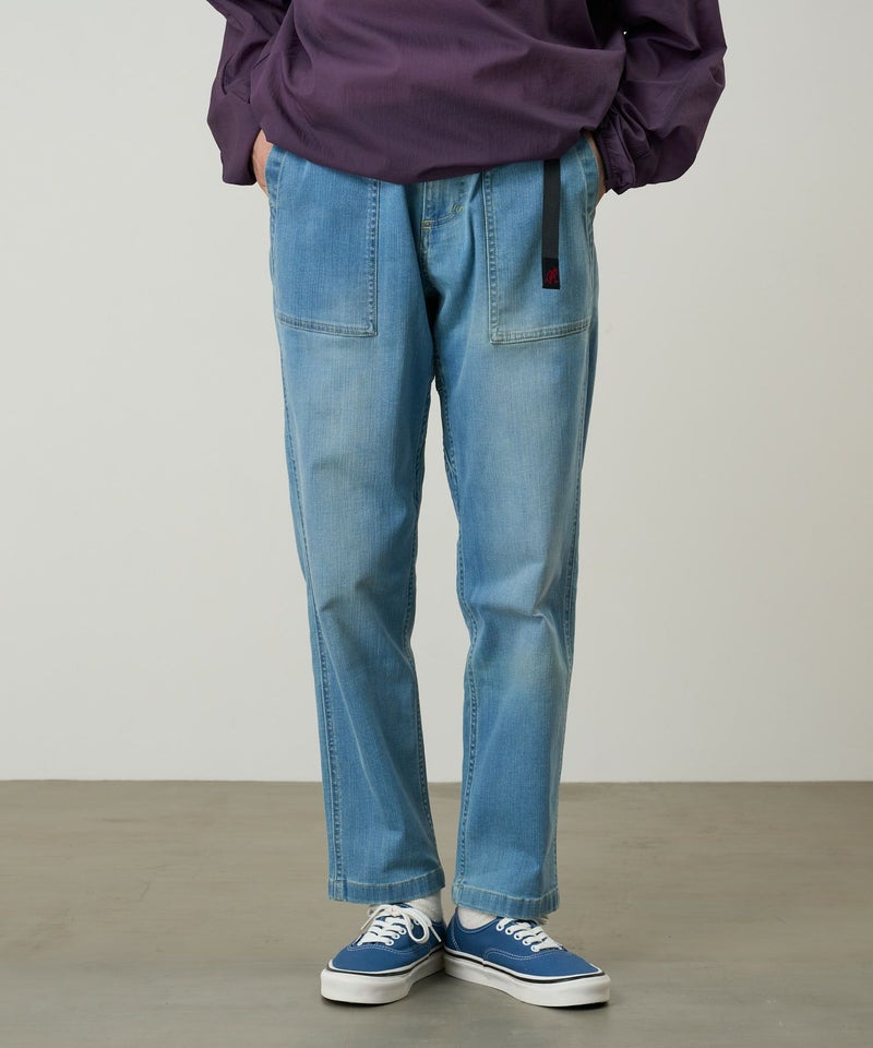 Front view of men's stretch denim loose tapered ridge pants worn by a model, showing front patch pockets and tapered legs.