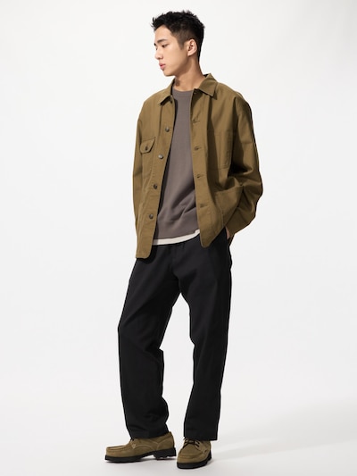 Male model wearing the men's stretch easy ankle pants in black.