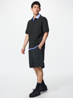 Male model wearing the men's shorts standing in a three-quarter view with hands in pockets.