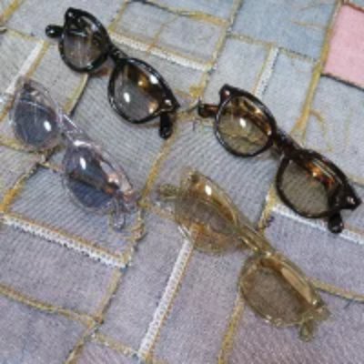 Multiple pairs of sunglasses arranged on a textured cloth surface.