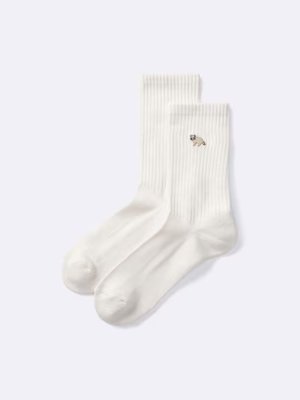 White cotton men's socks laid flat showing a small embroidered animal motif on the cuff.