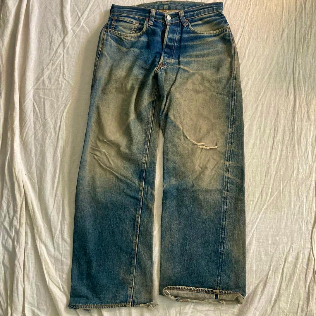 Full-length SUGAR CANE denim jeans laid flat showing the front with fading, whiskering, and knee distressing.