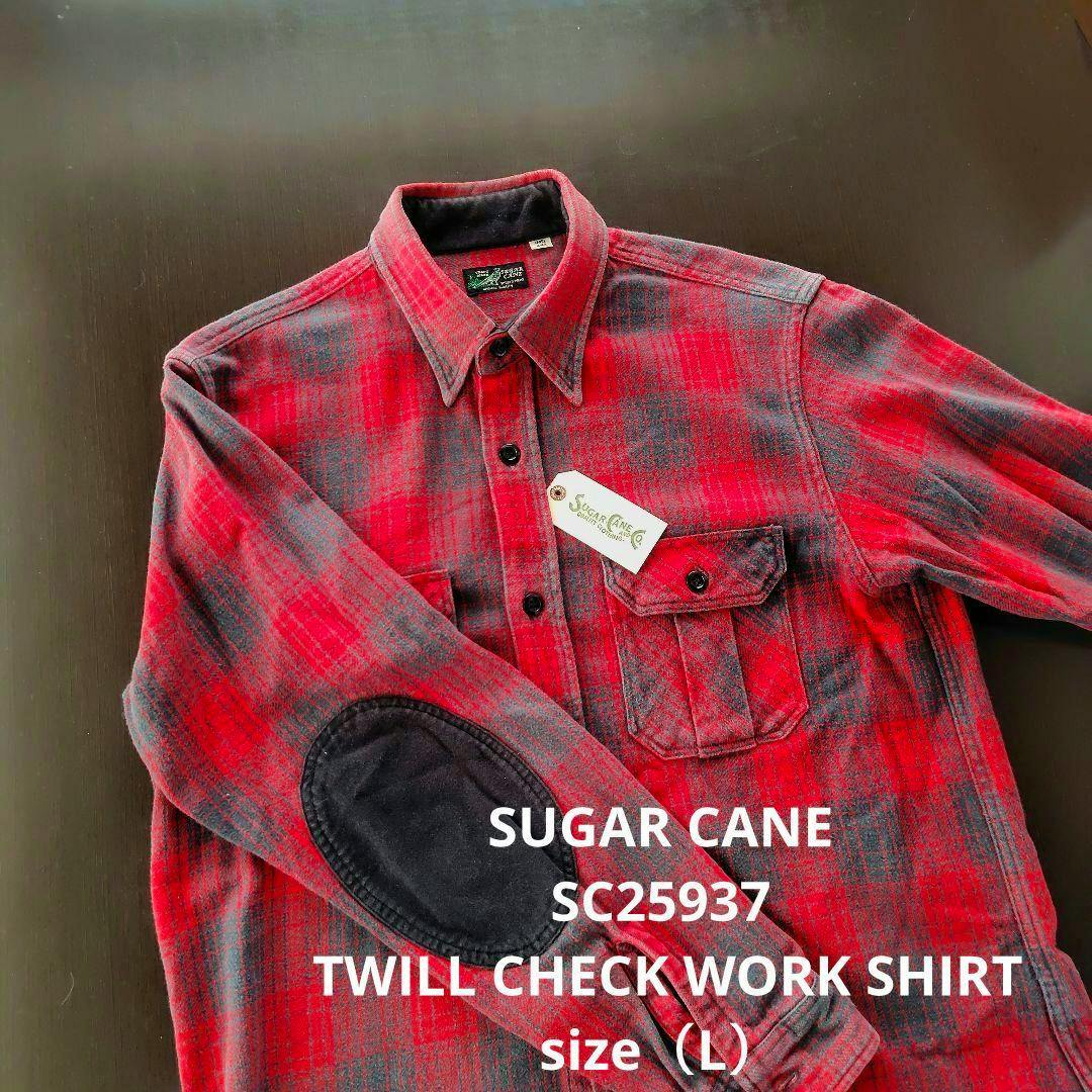 Red and gray twill check men's work shirt with a black elbow patch laid flat on a dark surface.