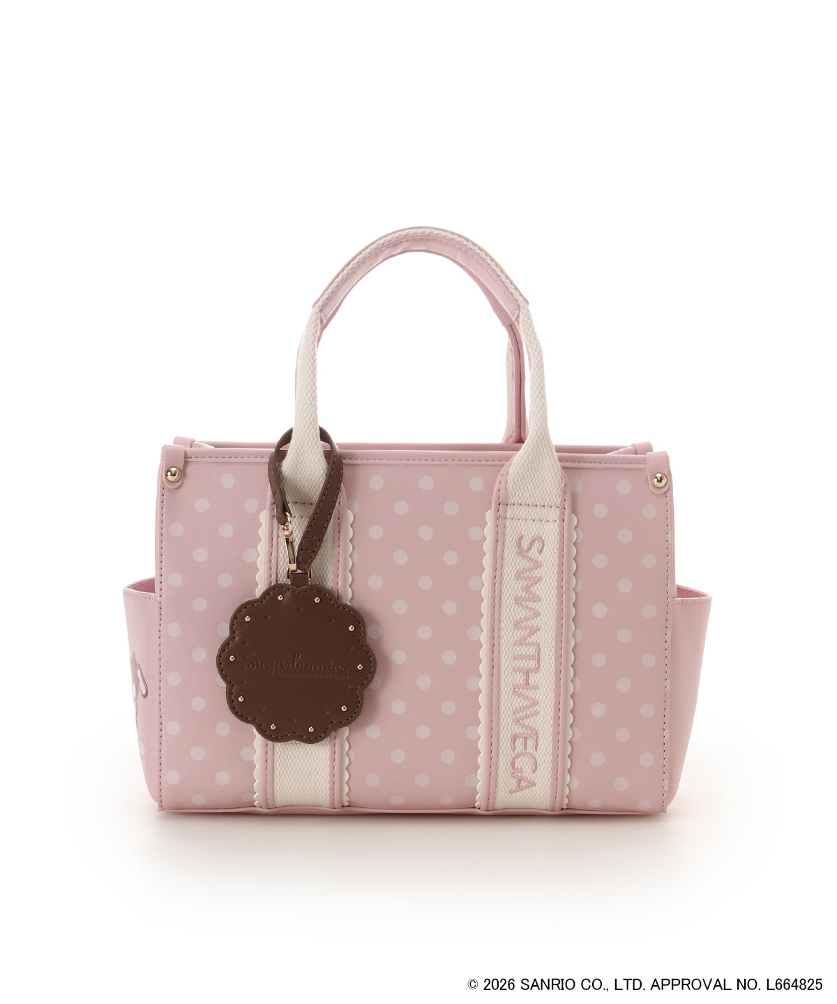 Pink polka-dot “シュガーバニーズ” cow leather handbag with top handles, side pockets, and a brown scalloped tag on a white background.