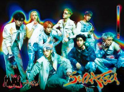 Cover art for the CD SUIATSU＜初回生産限定盤B＞ showing a group of band members posing with colorful neon effects.