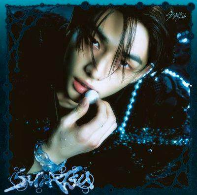 Cover art for the CD showing a close-up portrait of a person holding a small round object against a dark decorative background.