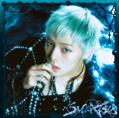 CD cover art showing a close-up portrait of a person with pale blue hair holding beads against a blue background.