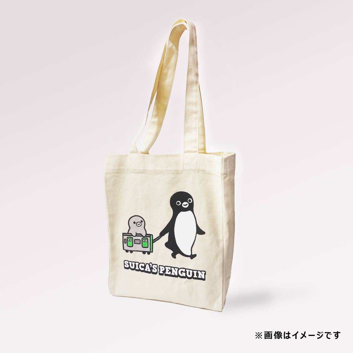 Ivory canvas tote bag with Suica's Penguin graphic and long shoulder handles, shown at a slight angle.