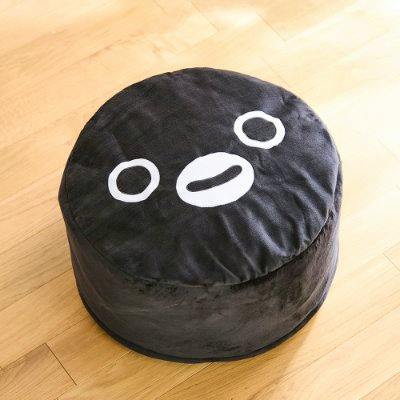 Round black cushion with a stylized penguin face printed on top, shown on a wooden floor.