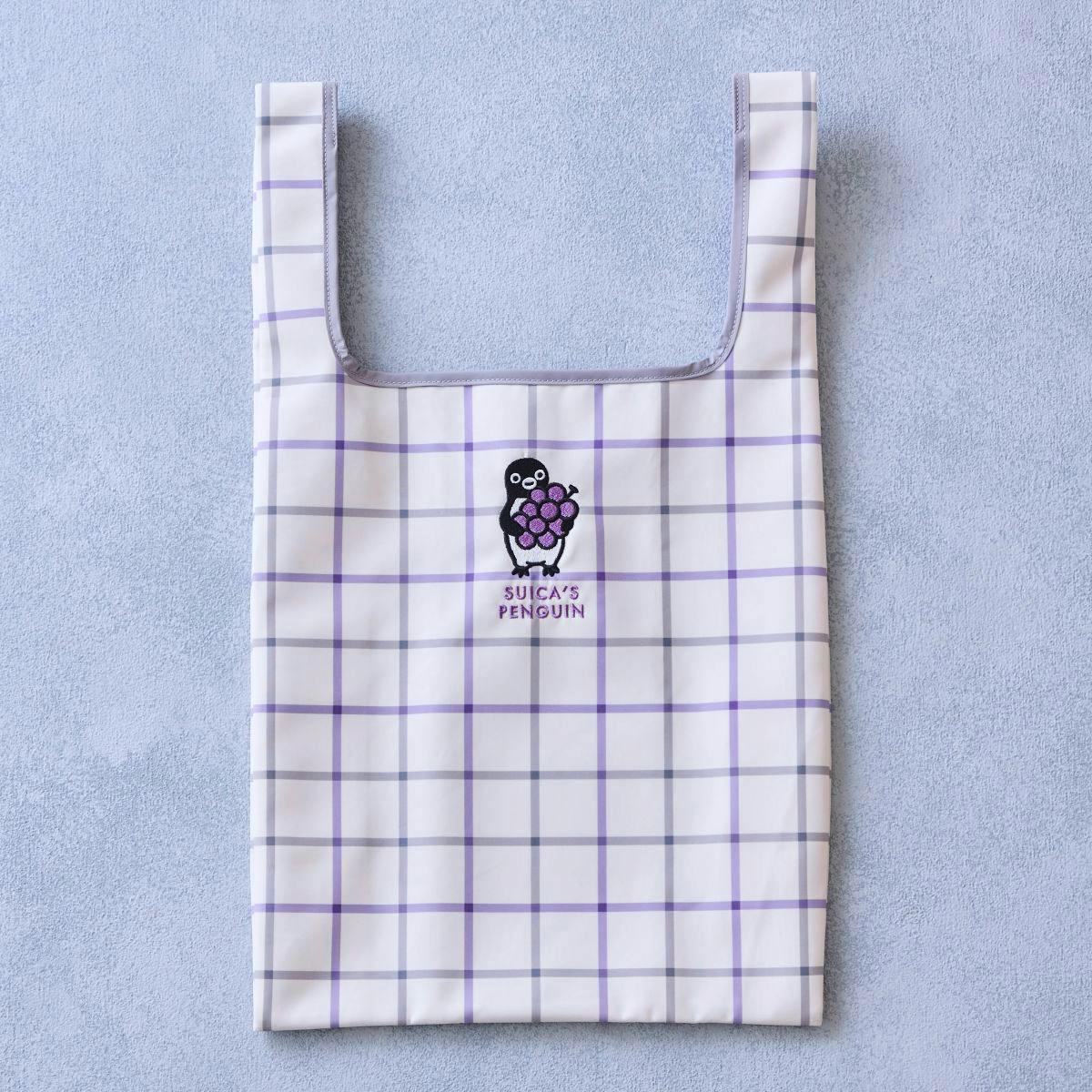 White and purple checked polyester eco bag shown flat with Suica's Penguin embroidered holding grapes on the front.