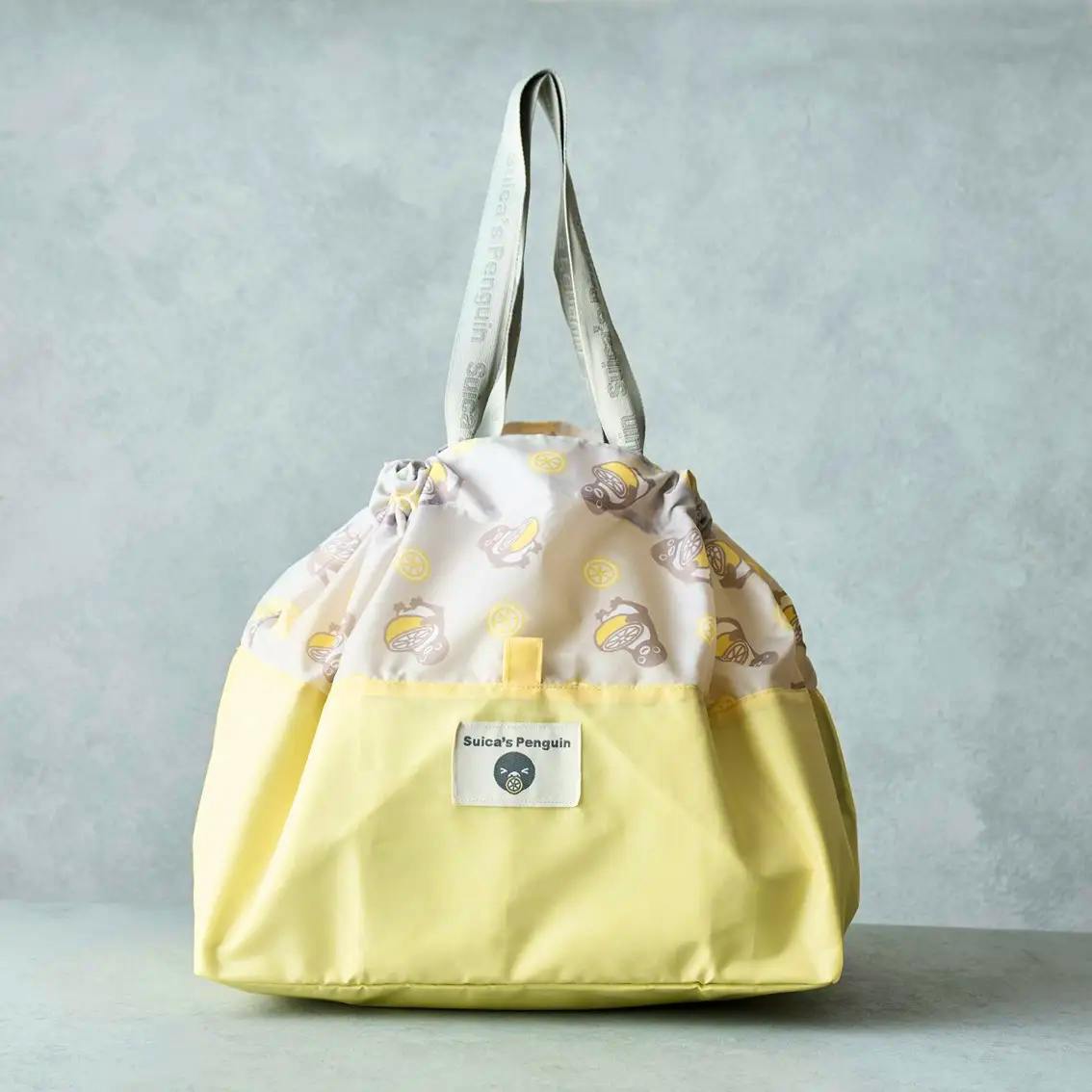 Lemon-colored Suica's Penguin drawstring eco bag with printed top panel and gray shoulder straps.