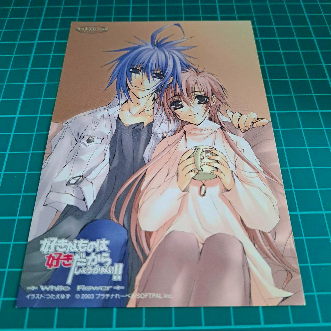 Postcard for "好きなものは好きだからしょうがない" showing two seated anime characters photographed on a green cutting mat.