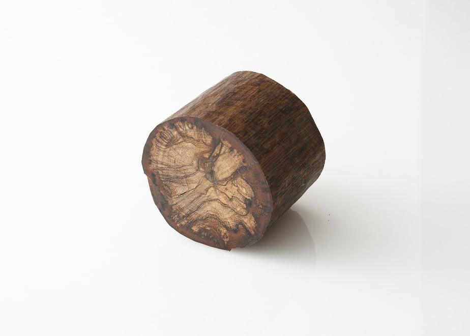 A small cylindrical piece of incense wood shown on a white background.