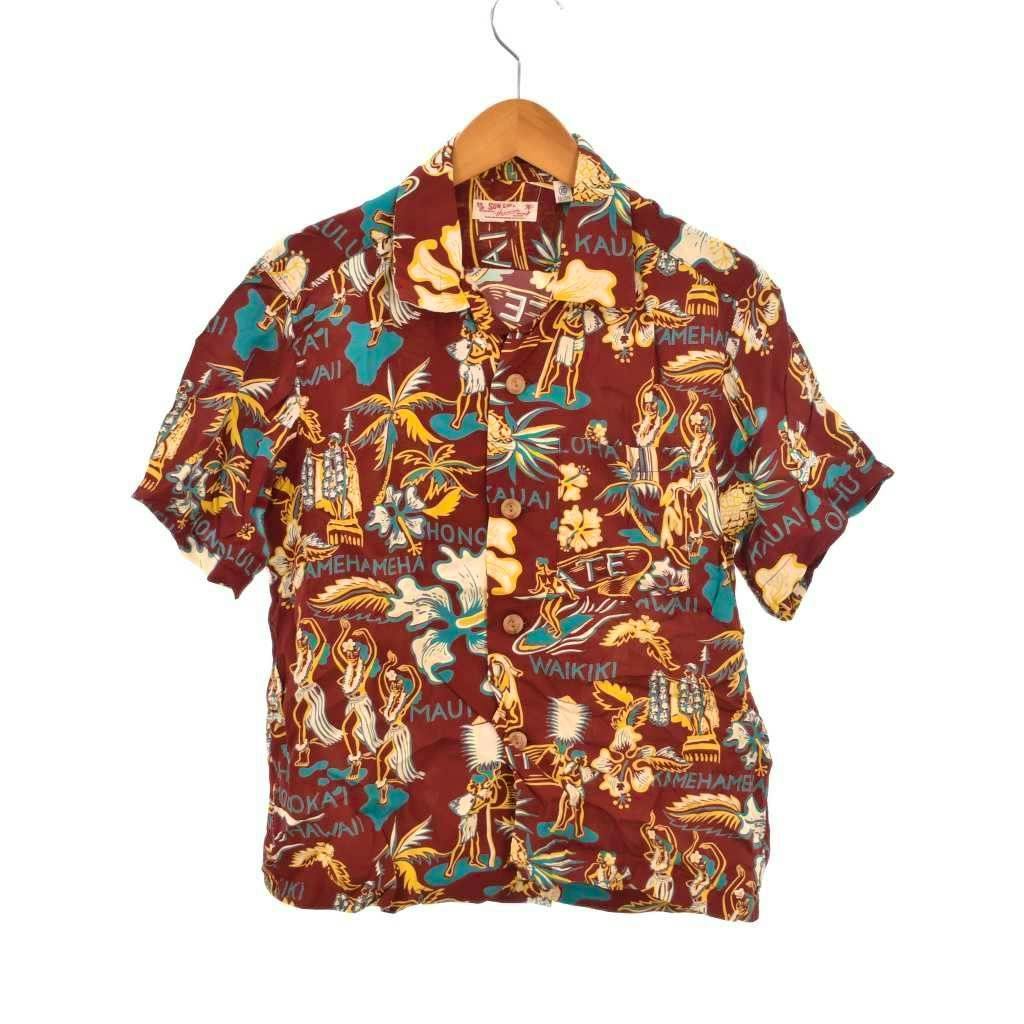 Front view of a men's short-sleeve rayon aloha shirt on a hanger with a burgundy background and multicolored hula-dance motif.