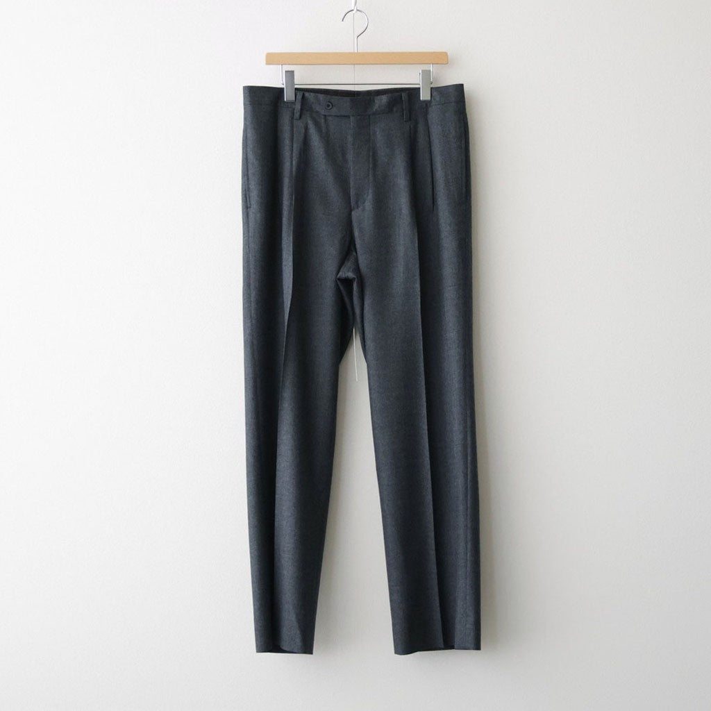 Charcoal two-tuck wool slacks hanging on a hanger against a white background.