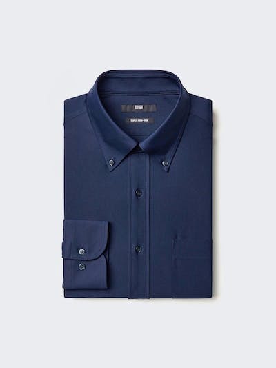 A folded men's button-down shirt in navy, showing the collar, cuff, buttons, and chest pocket.