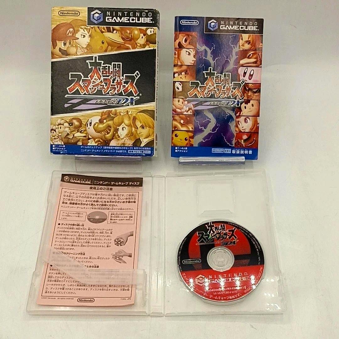 GameCube "大乱闘スマッシュブラザーズDX" box, instruction booklet, and disc shown in an open case on a white background.