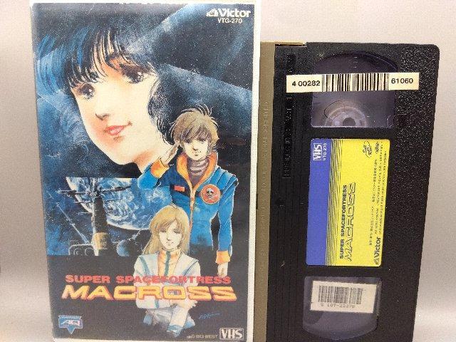 VHS tape and its illustrated sleeve for Super Spacefortress Macross shown side by side.