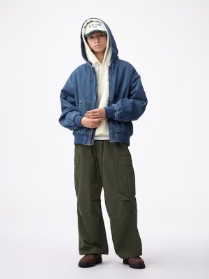 Model wearing olive-green super wide cargo pants paired with a denim jacket and hoodie.