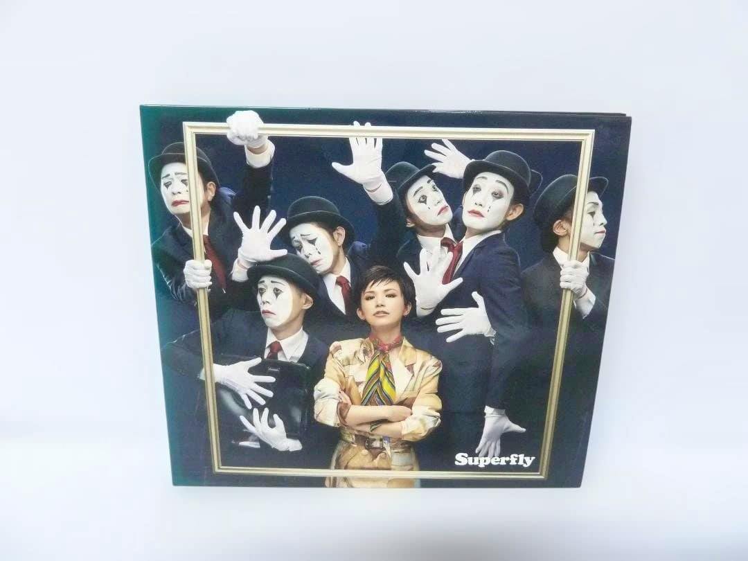 Front cover of the Ambitious (初回限定盤Blu-ray) by Superfly showing the package cover with the artist and several figures in mime makeup.