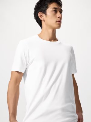 Male model wearing a white Supima cotton crew-neck T-shirt shown from mid-torso up.