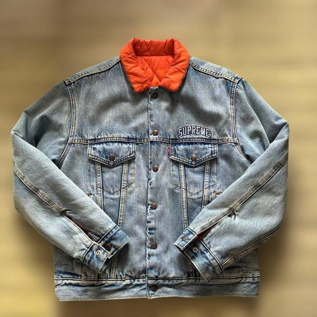 Flat-lay front view of the Supreme Levi's reversible denim jacket showing the blue denim exterior with an orange quilted collar.