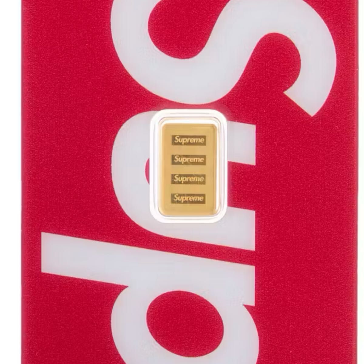 A Supreme PAMP Suisse 1g gold bar showing repeated "Supreme" inscriptions in a clear blister on a red Supreme-branded background.