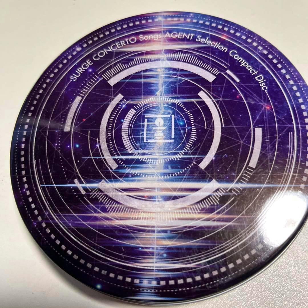 Top view of a compact disc showing purple circular sci‑fi artwork and the text “SURGE CONCERTO Songs AGENT Selection Compact Disc.”