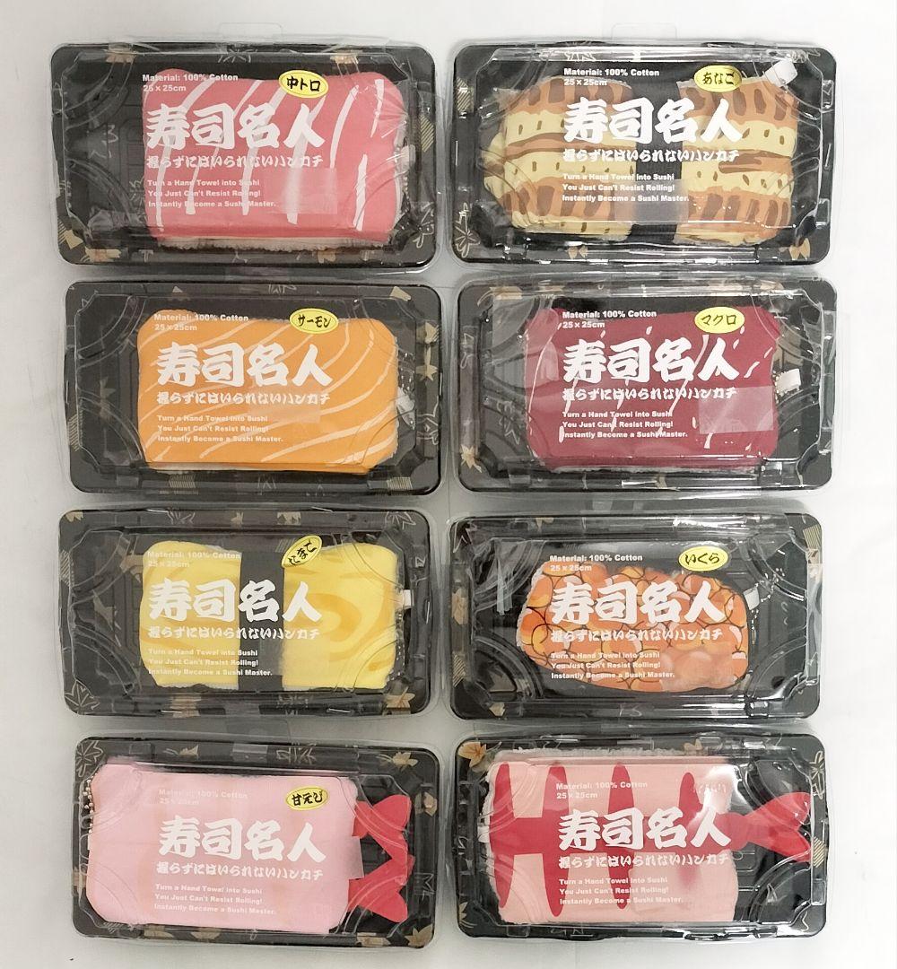 Eight packaged sushi-themed cotton hand towels displayed in black plastic trays.