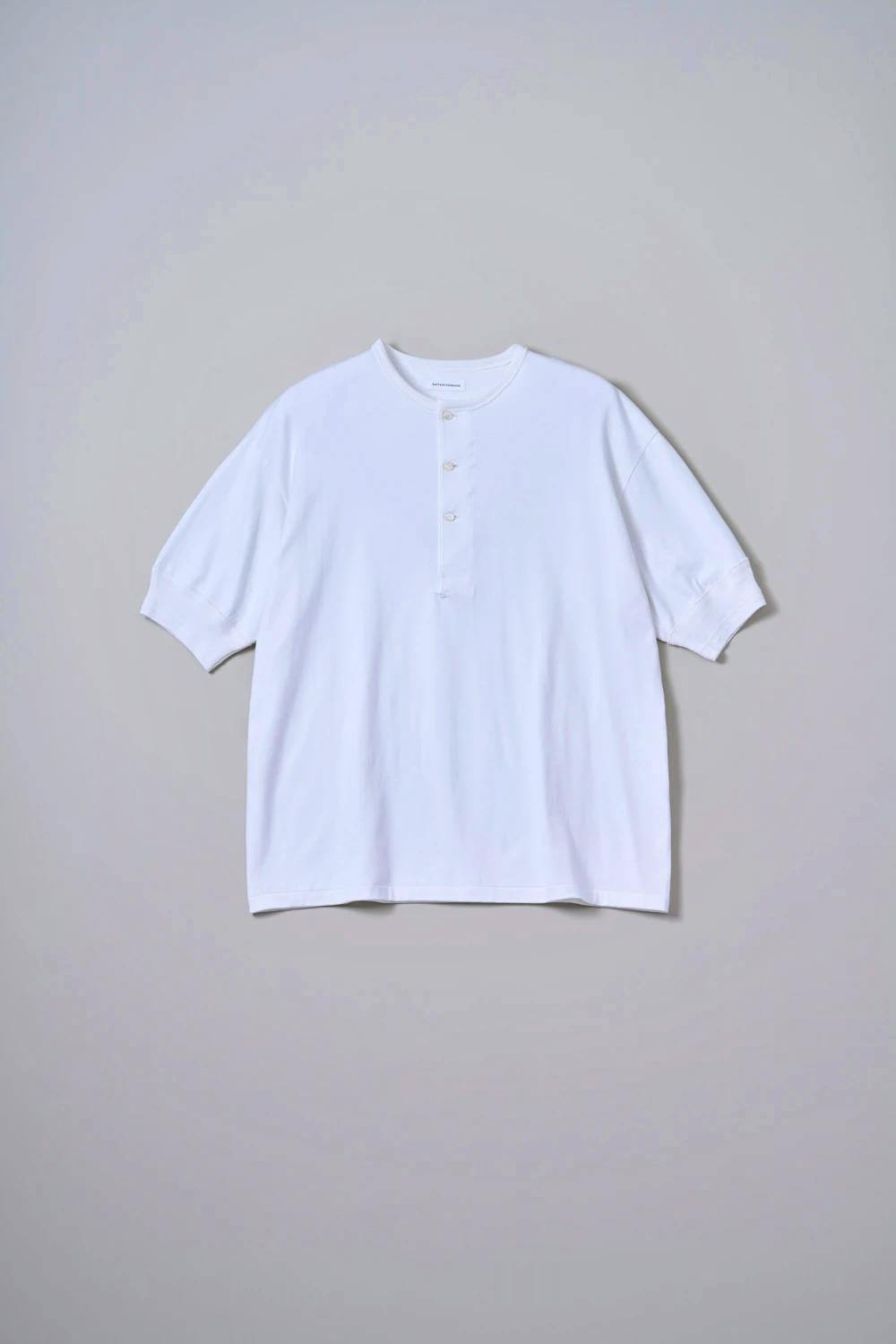 White Suvin Supima Tube Henleyneck tee laid flat showing the front with a three-button henley placket.