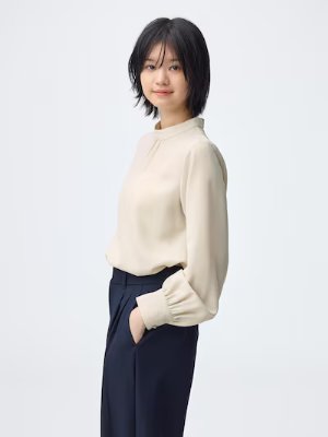 Model wearing the women's dolman-sleeve cardigan in a light beige color, shown in a side pose.