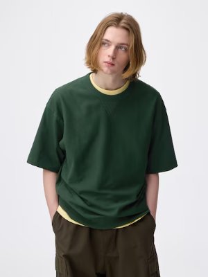 A model wearing a dark green cotton T-shirt with mid-length sleeves.