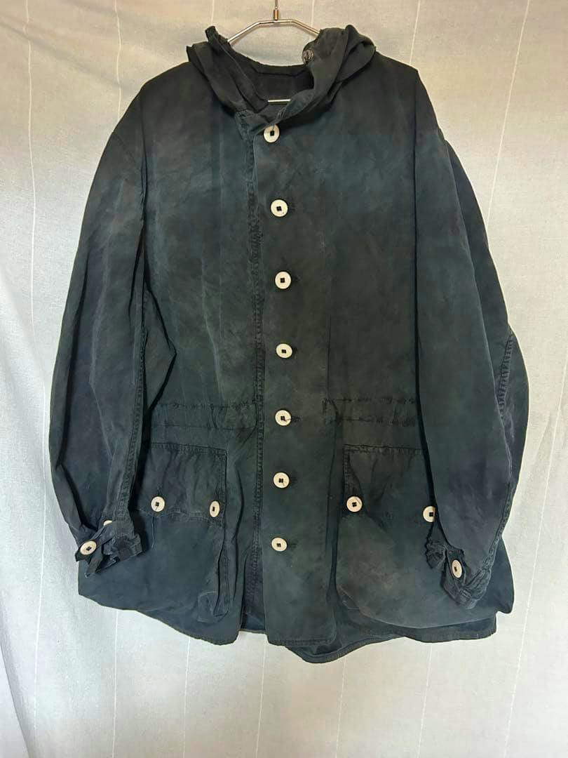 Front view of a vintage 50s/60s Swedish army snow parka M-62 hanging on a hanger, showing buttons and pockets.
