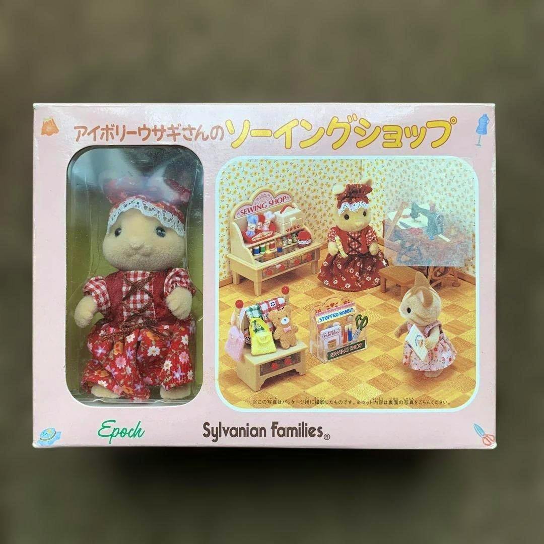 Packaged Sylvanian Families Ivory Rabbit sewing shop doll set showing the rabbit figure visible through a clear window and a printed scene on the box.