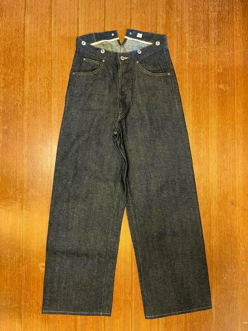 Front view of T.T Taiga Takahashi denim jeans laid flat on a wooden surface.
