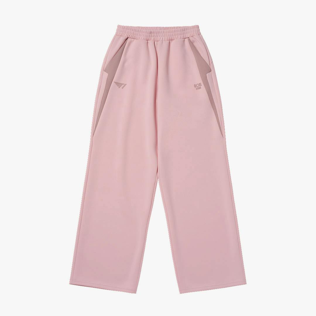 Front view of the T1 CLUBHOUSE W'S track pants in pink laid flat with elastic waistband and side pockets.