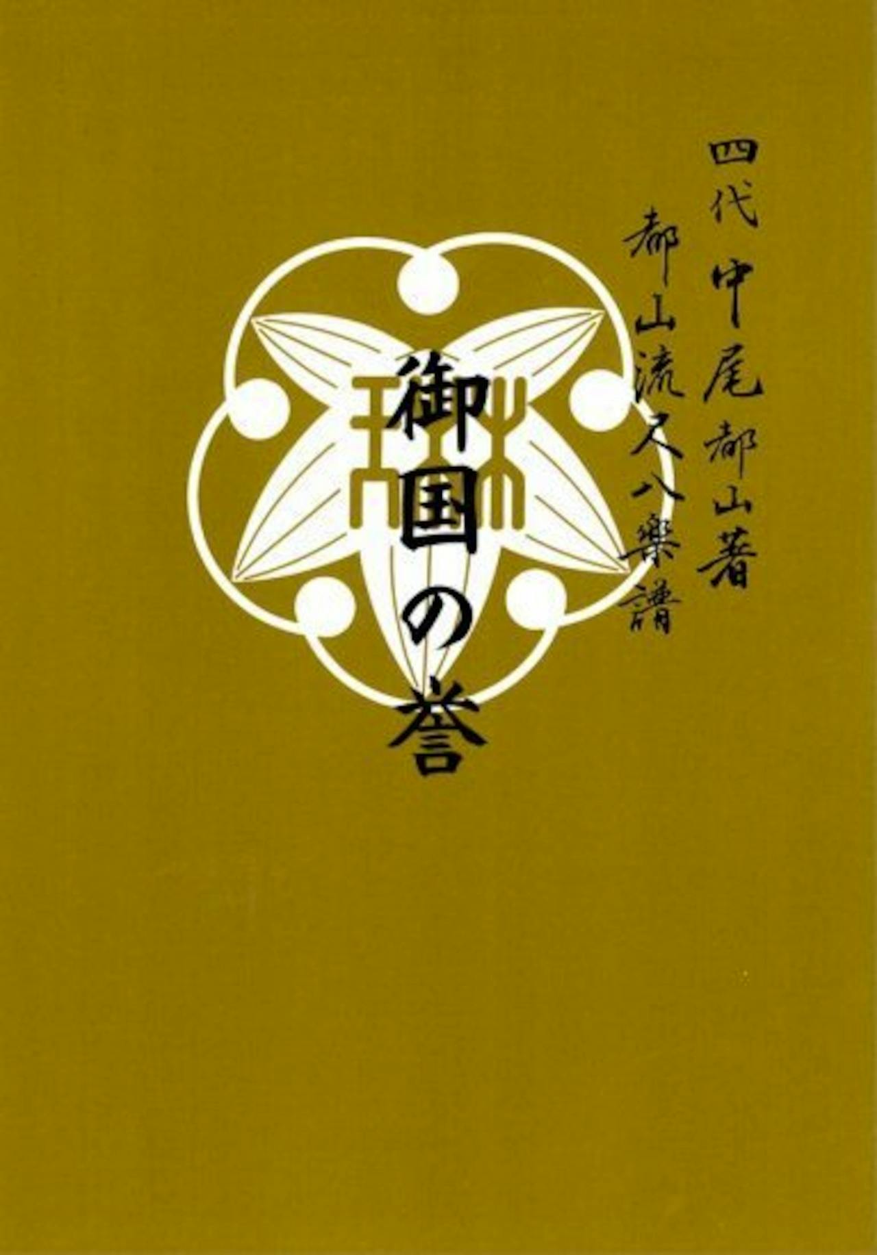 Front cover of the book with a mustard-yellow background, a white decorative emblem, and Japanese title text.