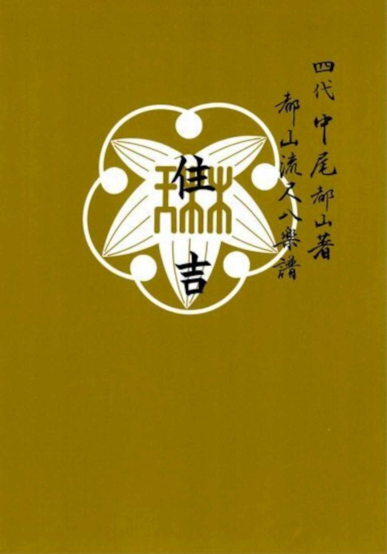 Front cover of the book showing a mustard-gold background with a white decorative emblem and vertical Japanese text.
