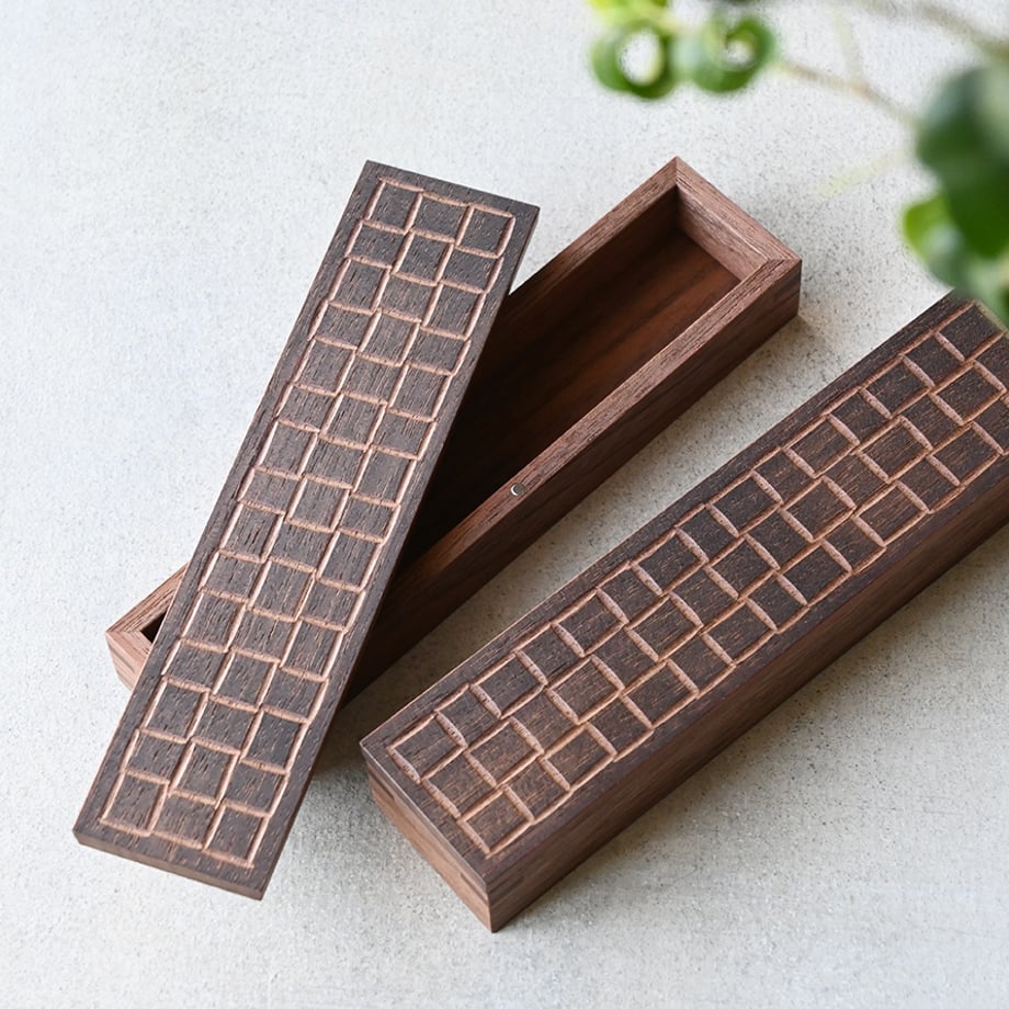 Wooden incense box (お線香箱) with a carved grid pattern, shown open beside a closed matching box on a light surface.