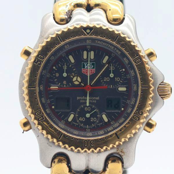 Front close-up of the TAG Heuer digital-analog chronograph watch showing the grey dial, tachymeter scale, and two-tone case.