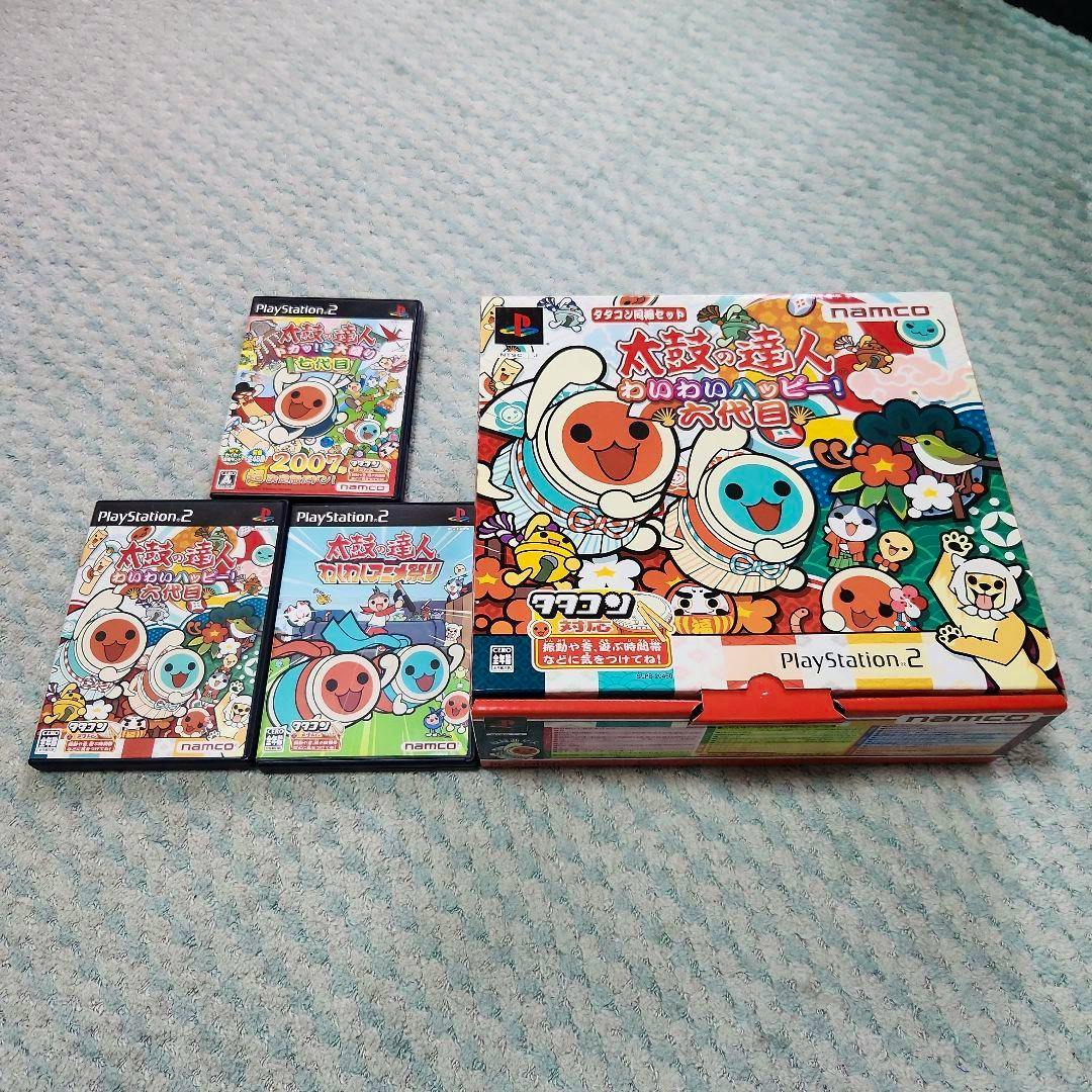 Large boxed Taiko no Tatsujin tatacon bundle for PlayStation 2 shown with three PlayStation 2 game cases and one smaller case on a patterned carpet.