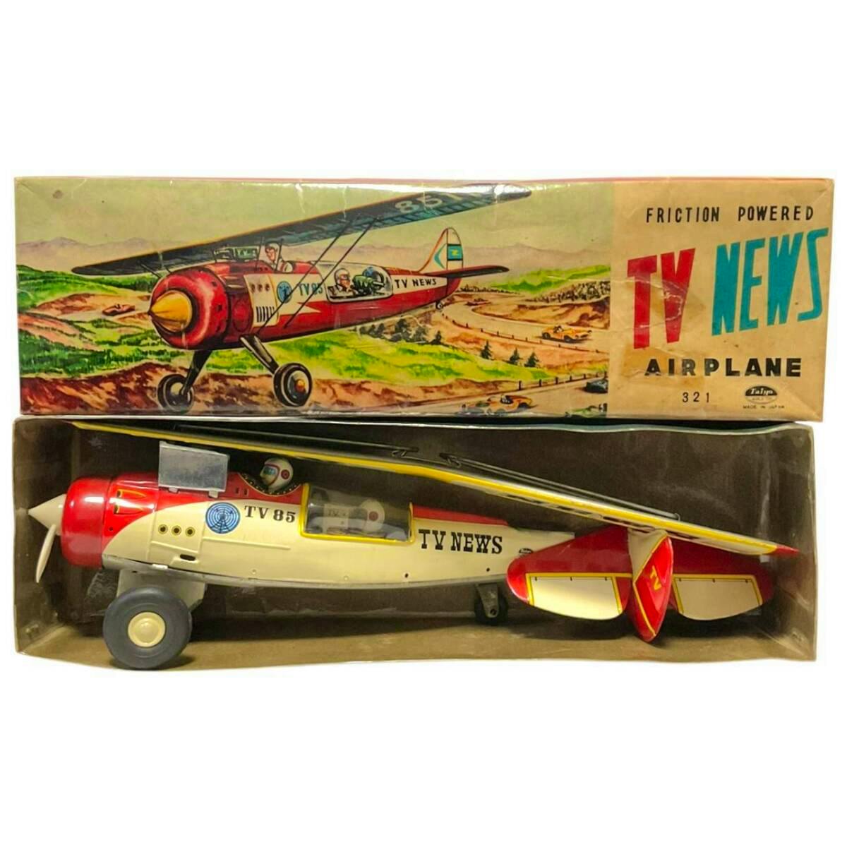 Tin friction-powered "TV News" airplane toy (TV 85) displayed inside its illustrated box.