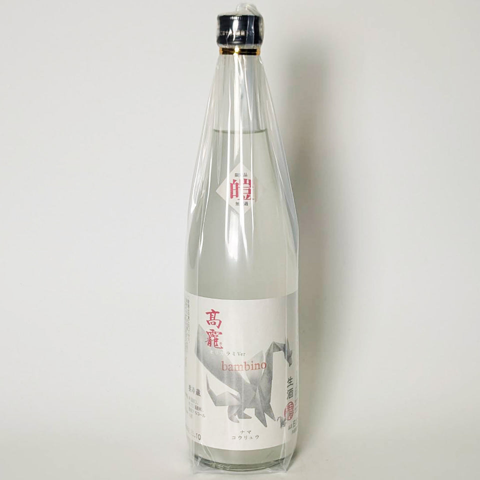 Front view of the sake bottle showing its label and plastic wrapping.